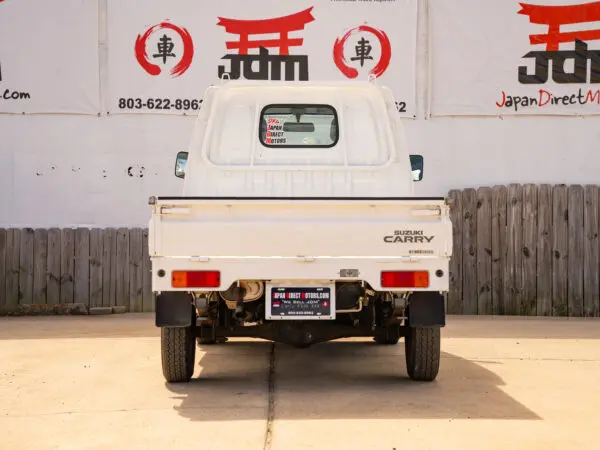 White Suzuki Carry truck parked outside.