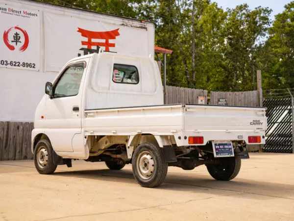 White Suzuki Carry truck parked outdoors.