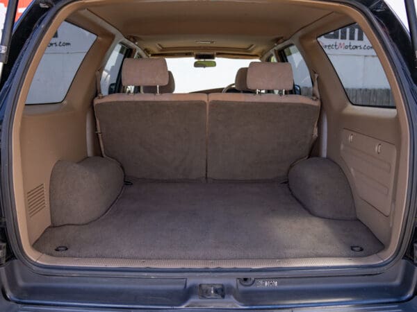 Empty car trunk with beige carpet.