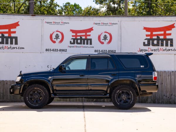 Black Toyota Land Cruiser SUV side view.