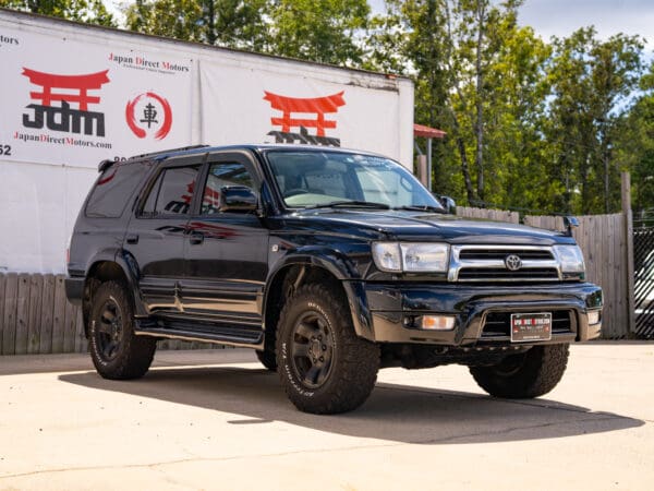 Black Toyota Land Cruiser SUV on asphalt.