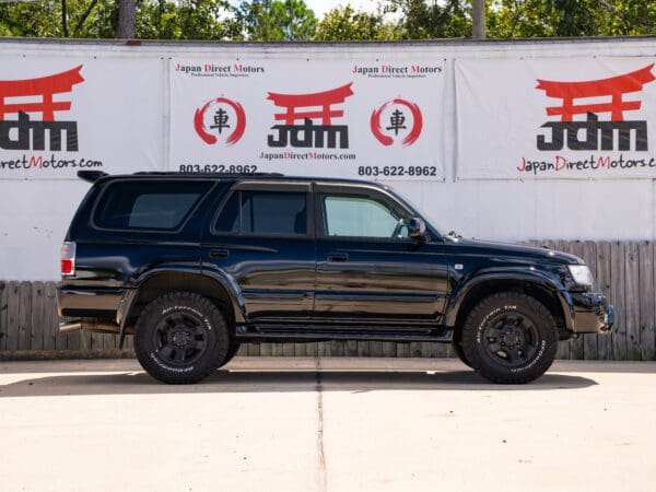 Black Toyota Land Cruiser SUV side view.