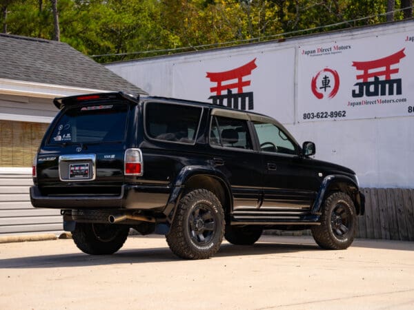 Black SUV parked in front of a sign.