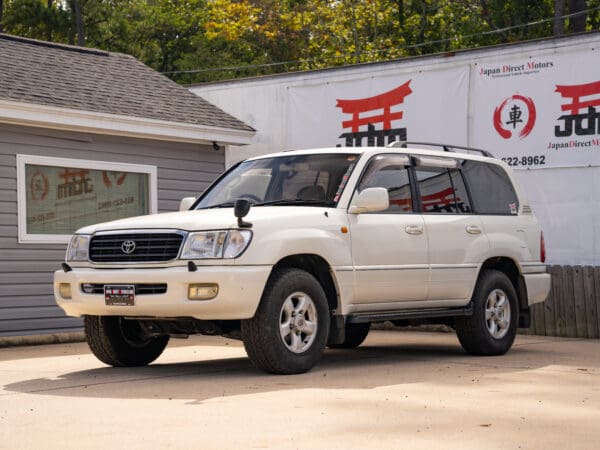 White Toyota Land Cruiser SUV parked outside.