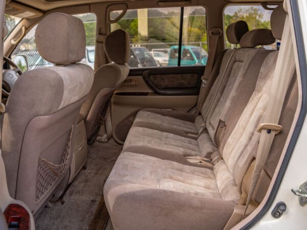 Beige fabric car seats with safety belts.