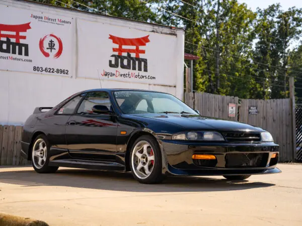 Black Nissan Skyline R33 parked outdoors.