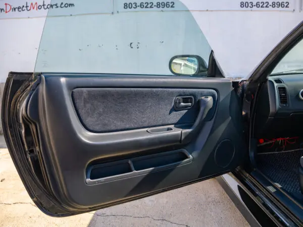 Black car door open, interior view.