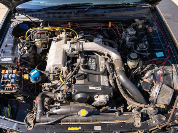 Open hood view of a Nissan engine.