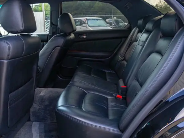 Black leather back seats of car.