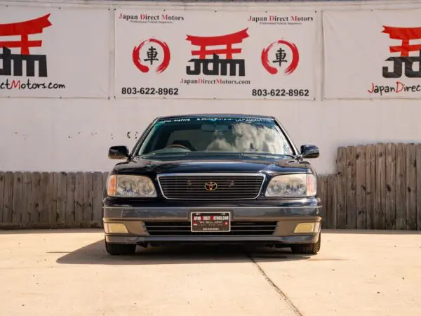 Black Lexus LS400 in front of a wall.