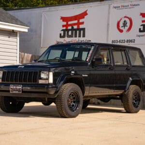 Black Jeep Cherokee in front of dealership.