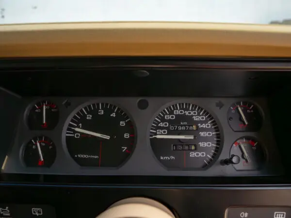 Car dashboard with speedometer, tachometer, and gauges.