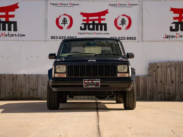 Black Jeep Cherokee in front of a building.