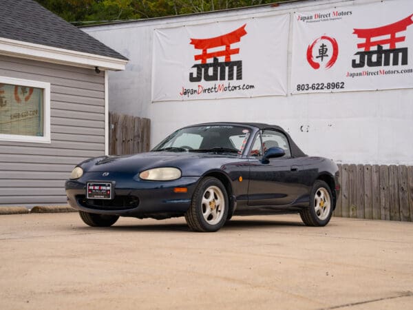 Blue Mazda Miata convertible parked outdoors.