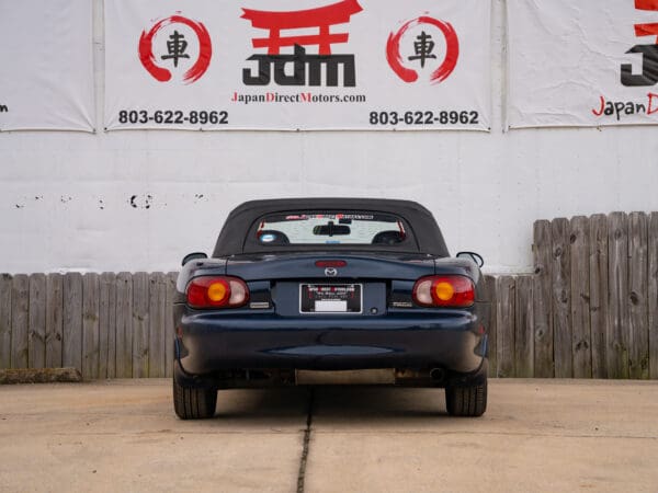 Blue Mazda Miata convertible parked.