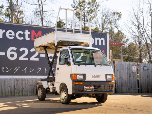 White mini dump truck with cage.