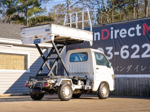 White mini dump truck with lift.