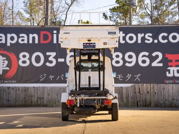 White Daihatsu mini-truck, rear view.