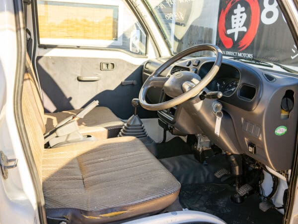 White mini truck interior, driver's seat.