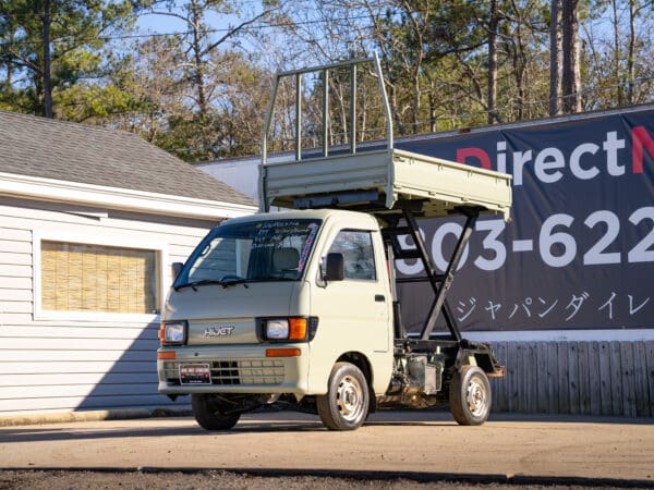 Light green Daihatsu Hijet mini truck.